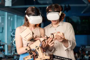 Berufsbildung 2035 – Chancen und Perspektiven immersiver Lernumgebungen – Beitrag von conceptk; Foto: 2 Auszubildende mit VR-Brille und Roboterarm